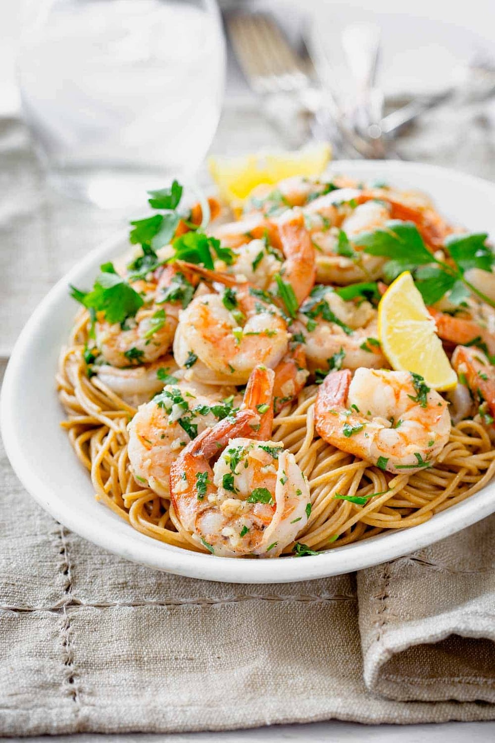 shrimp over pasta on a white platter
