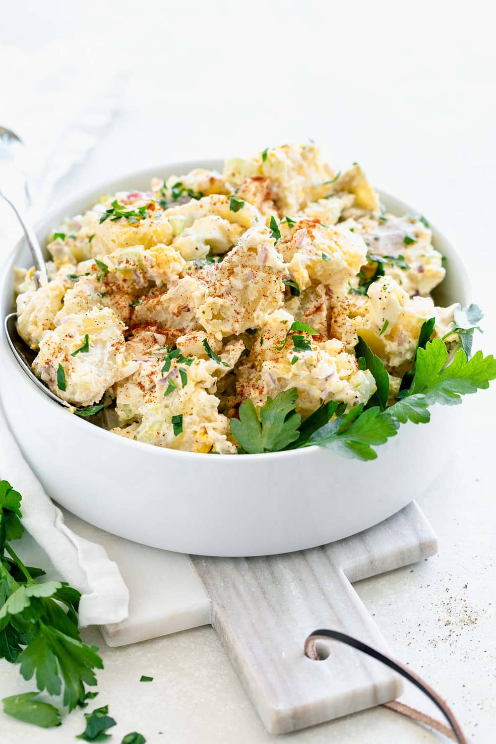 classic potato salad in a white bowl with backlight