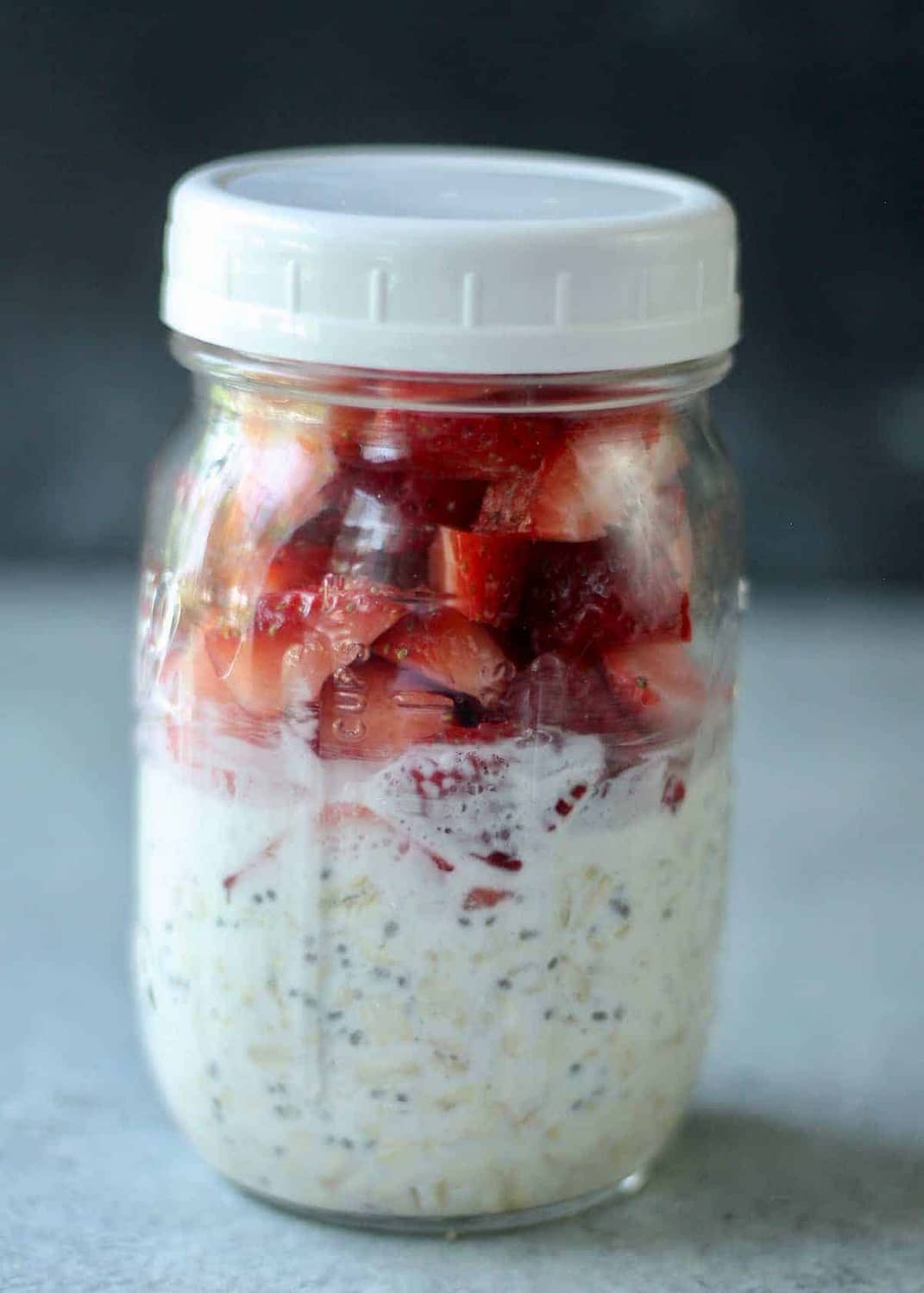Mason jar of overnight oats with fresh strawberries.